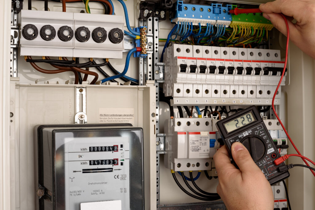 Elektriker misst Spannung im Stromkasten